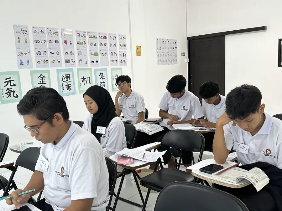 漢字表のある教室で集中して学習する生徒たち
